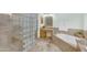 Bright bathroom with a tiled shower and a garden tub, featuring a granite-topped vanity and glass block accents at 12605 E Kalil Dr, Scottsdale, AZ 85259