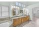 Spa-like bathroom with a soaking tub, granite countertops, double sinks, and plantation shutters at 12605 E Kalil Dr, Scottsdale, AZ 85259