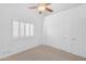 This bedroom features a ceiling fan, carpet flooring, a window with shutters, and a closet at 12605 E Kalil Dr, Scottsdale, AZ 85259