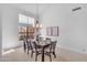 Bright dining room with large windows, chandelier and table set for six guests at 12605 E Kalil Dr, Scottsdale, AZ 85259