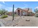 Desert home showcasing a stucco exterior, rock landscaping, and mature Saguaro cactus at 12605 E Kalil Dr, Scottsdale, AZ 85259