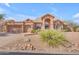 Charming single-Gathering home featuring desert landscaping, a tile roof, and a three-car garage at 12605 E Kalil Dr, Scottsdale, AZ 85259