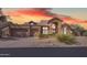 Stunning home with a tan stucco exterior, tile roof, and well-maintained landscaping against a sunset sky at 12605 E Kalil Dr, Scottsdale, AZ 85259