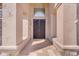 Elegant front entrance boasting tiled flooring, a secure iron door, and an arched transom window at 12605 E Kalil Dr, Scottsdale, AZ 85259