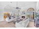 Bright living room showcasing a cozy fireplace, white sofas, and an open floor plan to the kitchen at 12605 E Kalil Dr, Scottsdale, AZ 85259