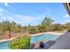 A refreshing pool is surrounded by lush landscaping and mature trees, creating a private oasis at 12605 E Kalil Dr, Scottsdale, AZ 85259