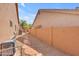 Narrow side yard with gravel, stone path, and beige block wall providing utility access and functionality at 12605 E Kalil Dr, Scottsdale, AZ 85259