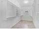 Walk-in closet with built-in shelving and racks providing ample storage space, and natural light from a window at 12605 E Kalil Dr, Scottsdale, AZ 85259