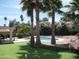 Beautiful backyard with pool, putting green, lush palms, and lounge chairs for relaxation and leisure at 1333 N Higley Rd # 7, Mesa, AZ 85205