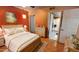 Comfortable main bedroom with orange accent wall and bathroom entrance at 1440 N Idaho Rd # 1022, Apache Junction, AZ 85119