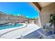 Staged backyard with seating area, barbecue, and in-ground pool with waterfall at 1623 E Runion Dr, Phoenix, AZ 85024