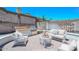 Staged backyard with seating area, barbecue, and stone wall with lush trees at 1623 E Runion Dr, Phoenix, AZ 85024