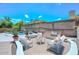 Staged backyard with seating area, barbecue, and in-ground pool surrounded by stone at 1623 E Runion Dr, Phoenix, AZ 85024