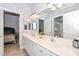 Bright bathroom with double sinks, vanity, and a large mirror with access to other rooms at 1623 E Runion Dr, Phoenix, AZ 85024