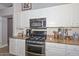 Modern kitchen with stainless steel appliances, gas range, granite counters, and white cabinets at 1623 E Runion Dr, Phoenix, AZ 85024