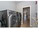 Laundry room with front load washer and dryer and passageway to the backyard at 1623 E Runion Dr, Phoenix, AZ 85024
