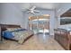 A spacious main bedroom featuring neutral walls, a ceiling fan, a large bed and a stunning pool view at 1623 E Runion Dr, Phoenix, AZ 85024