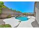 An inviting pool area with a rock waterfall and lush landscaping, creating a serene backyard escape at 1623 E Runion Dr, Phoenix, AZ 85024