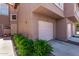 Townhome featuring an attached garage, and green landscaping, creating an inviting curb appeal at 1633 E Lakeside Dr # 156, Gilbert, AZ 85234