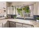 Bright kitchen features hexagon tile backsplash, granite countertops, and a farmhouse style sink at 1633 E Lakeside Dr # 156, Gilbert, AZ 85234