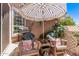 Relaxing outdoor patio featuring a grill, seating, striped umbrella, and mature landscaping at 1633 E Lakeside Dr # 156, Gilbert, AZ 85234