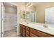 Well-lit bathroom with a double vanity, ample counter space, a large mirror, and a shower-tub combo at 16450 W Lilac St, Goodyear, AZ 85338