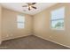 Bedroom featuring neutral walls, carpet, ceiling fan, and two windows for natural light at 16450 W Lilac St, Goodyear, AZ 85338
