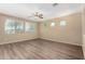 Bright room with wood flooring, large windows, and a ceiling fan at 16450 W Lilac St, Goodyear, AZ 85338