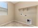 Functional laundry room with shelving and hookups for a washer and dryer at 16450 W Lilac St, Goodyear, AZ 85338