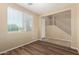 Well-lit room with wood flooring, a large window with blinds, and an open entryway with stairs at 16450 W Lilac St, Goodyear, AZ 85338