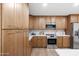 Well-lit kitchen with wooden cabinets, stainless steel appliances, and white countertops at 1713 W Royal Palm Rd, Phoenix, AZ 85021