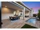 Inviting covered patio with wood tile, a dining area, an outdoor seating area, and a beautiful pool at 17146 W Mountainair St, Surprise, AZ 85388
