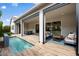 Inviting covered patio with wood tile, a dining area, an outdoor seating area, and a beautiful pool at 17146 W Mountainair St, Surprise, AZ 85388