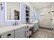 Bright bathroom featuring double vanity, quartz countertop, modern fixtures, and glass enclosed shower at 17146 W Mountainair St, Surprise, AZ 85388