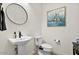 Cozy powder room featuring a pedestal sink, mirror, and toilet at 17146 W Mountainair St, Surprise, AZ 85388