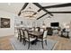 Elegant dining room with chandelier, exposed beams and an open floor plan into the kitchen and living area at 17146 W Mountainair St, Surprise, AZ 85388