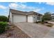 Charming home exterior featuring a three-car garage and a brick-paved driveway at 17146 W Mountainair St, Surprise, AZ 85388