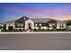 Beautiful home featuring a modern exterior paint scheme with manicured landscaping, set against a picturesque twilight sky at 17146 W Mountainair St, Surprise, AZ 85388