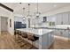 Modern kitchen with a large island, stylish bar stools, pendant lights, and high-end appliances for gourmet cooking at 17146 W Mountainair St, Surprise, AZ 85388