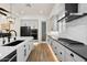 Modern kitchen with white cabinets, black appliances, and a kitchen island with a sleek black sink at 17146 W Mountainair St, Surprise, AZ 85388