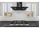 Bright kitchen featuring a KitchenAid range hood and subway tile backsplash, set against shuttered windows at 17146 W Mountainair St, Surprise, AZ 85388