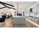 Open kitchen with large island, modern pendant lighting, and stainless steel appliances, flowing into the dining and living areas at 17146 W Mountainair St, Surprise, AZ 85388
