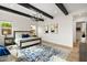 Bright main bedroom with exposed beams, chandelier, and ample natural light, showcasing a tranquil retreat at 17146 W Mountainair St, Surprise, AZ 85388