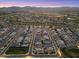 Panoramic aerial view of a vibrant neighborhood and golf course at twilight, showing well-lit streets and cozy homes at 17146 W Mountainair St, Surprise, AZ 85388