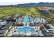 Aerial view of a resort-style pool with lush palm trees, cozy lounge chairs, and views of the golf course at 17146 W Mountainair St, Surprise, AZ 85388