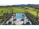 Aerial view of a beautiful community pool, lined with palm trees and surrounded by comfortable lounge chairs at 17146 W Mountainair St, Surprise, AZ 85388
