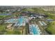 Stunning aerial view of a community pool with palm trees and plenty of seating and community buildings nearby at 17146 W Mountainair St, Surprise, AZ 85388