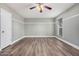 Bright bedroom featuring wood-look floors, a ceiling fan, and a window bringing in natural light at 17201 N 35Th Dr, Glendale, AZ 85308