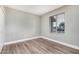 Bedroom with wood-look floors, white trim, and a large window with blinds at 17201 N 35Th Dr, Glendale, AZ 85308
