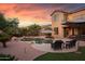View of the backyard featuring an in-ground pool, patio, lounge furniture, and desert landscaping at 18432 W Port Royale Ln, Surprise, AZ 85388